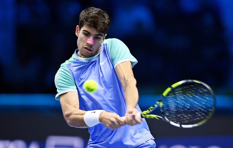 El tenista español Carlos Alcaraz devuelve una bola frente al ruso Andrey Rublev en su partido de las Finales ATP en Turín, Italia.