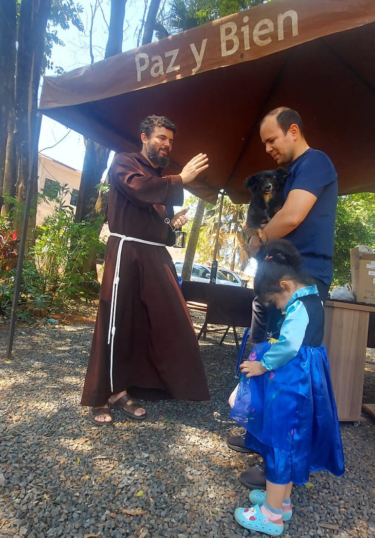 Un tierno momento: una niña reza mientras su mascota recibe la bendición del padre.