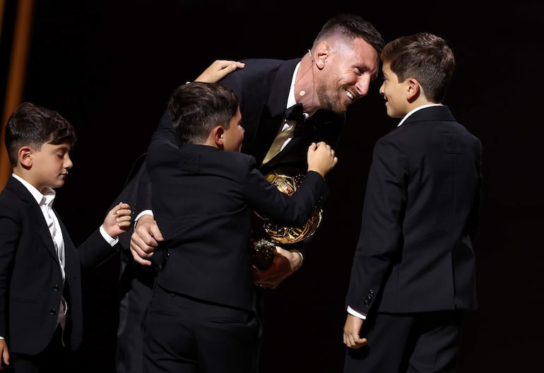 Lionel Messi con su octavo Balón de Oro, rodeado de sus tres hijos varones. (EFE/Mohammed Badra)
