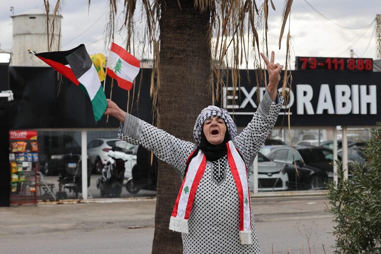 Una mujer con banderas de Líbano y Palestina celebra la tregua, este miércoles en la localidad de Sidon, en el sur de Líbano.