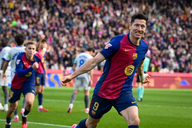 Barcelona's Polish forward #09 Robert Lewandowski (R) celebrates after scoring their first goal during the Spanish league football match between FC Barcelona and Deportivo Alaves at the Estadi Olimpic Lluis Companys in Barcelona on February 2, 2025. (Photo by Josep LAGO / AFP)