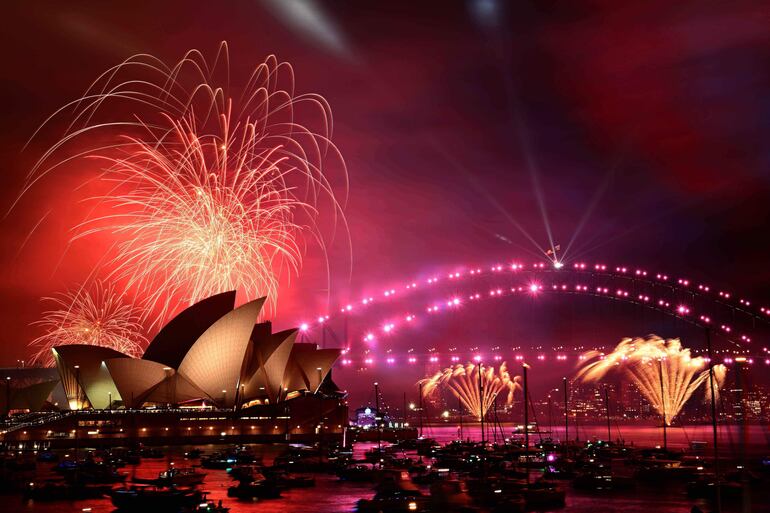 Fuegos artificiales iluminan el cielo sobre la Ópera y el Puente del Puerto durante las celebraciones del Año nuevo en Sydney, Australia. 