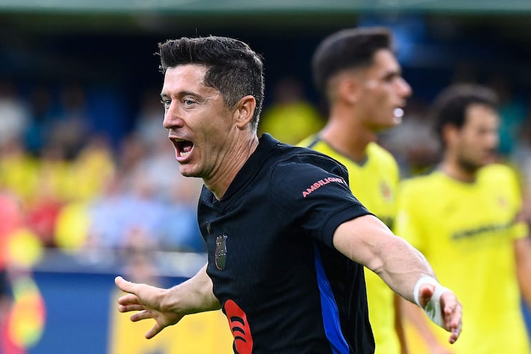 Barcelona's Polish forward #09 Robert Lewandowski celebrates after scoring his team's first goal during the Spanish league football match between Villarreal CF and FC Barcelona at La Ceramica stadium in Vila-real, on September 22, 2024. (Photo by JOSE JORDAN / AFP)