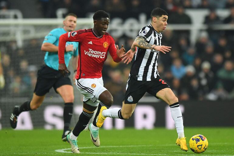 El centrocampista paraguayo #24 del Newcastle United, Miguel Almirón (derecha), huye del centrocampista inglés #37 del Manchester United, Kobbie Mainoo (izquierda), durante el partido de fútbol de la Premier League inglesa entre el Newcastle United y el Manchester United en St James' Park en Newcastle-upon-Tyne, noreste de Inglaterra, el 2 de diciembre de 2023.