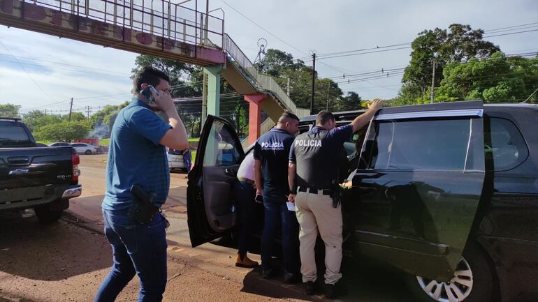 Los policías cuando verificaban el vehículo de las víctimas del asalto.