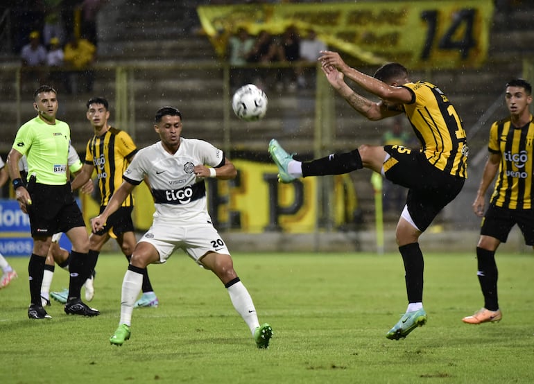 El defensor aurinegro Sabastián Zaracho rechaza el balón ante la llegada de Alex Franco.