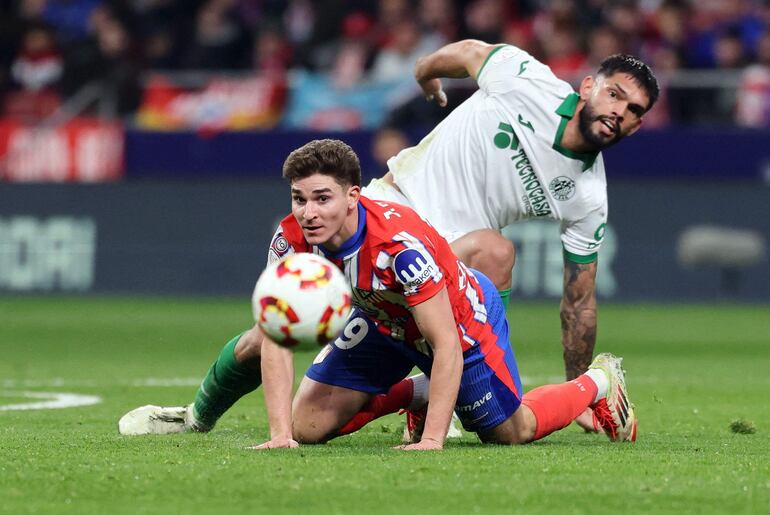 Atletico Madrid's Argentine forward #19 Julian Alvarez and Getafe's Paraguayan defender #15 Omar Alderete (R) vie for the ball during the Spanish Copa del Rey (King's Cup) quarter-final first leg football match between Club Atletico de Madrid and Getafe CF at Metropolitano Stadium in Madrid on February 4, 2025. (Photo by Thomas COEX / AFP)