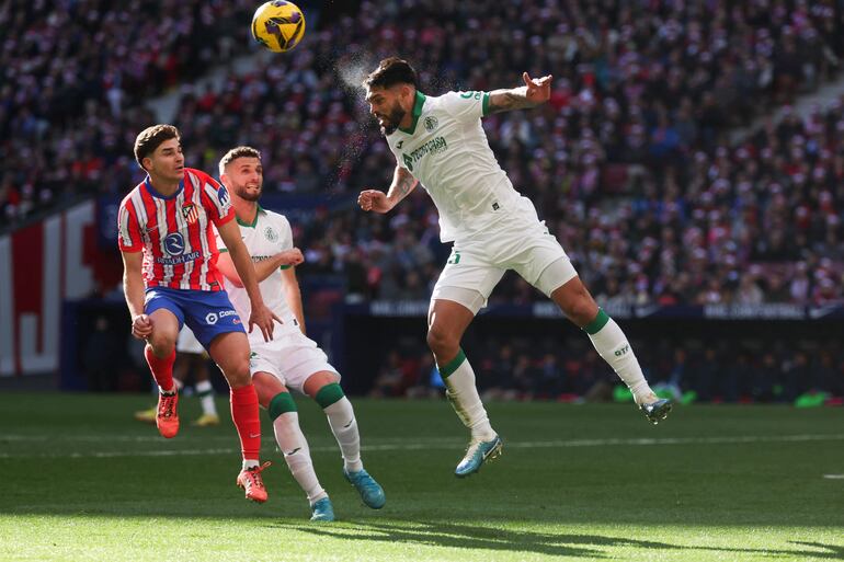 Getafe's Paraguayan defender #15 Omar Alderete (R) heads the ball challenged by Atletico Madrid's Argentine forward #19 Julian Alvarez during the Spanish league football match between Club Atletico de Madrid and Getafe CF at the Metropolitano stadium in Madrid on December 15, 2024. (Photo by Pierre-Philippe MARCOU / AFP)