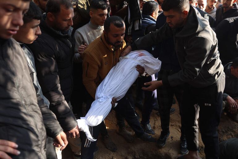 Un hombre lleva este sábado el cuerpo de una persona fallecida ayer en un bombardeo israelí en Jabalia, Gaza.