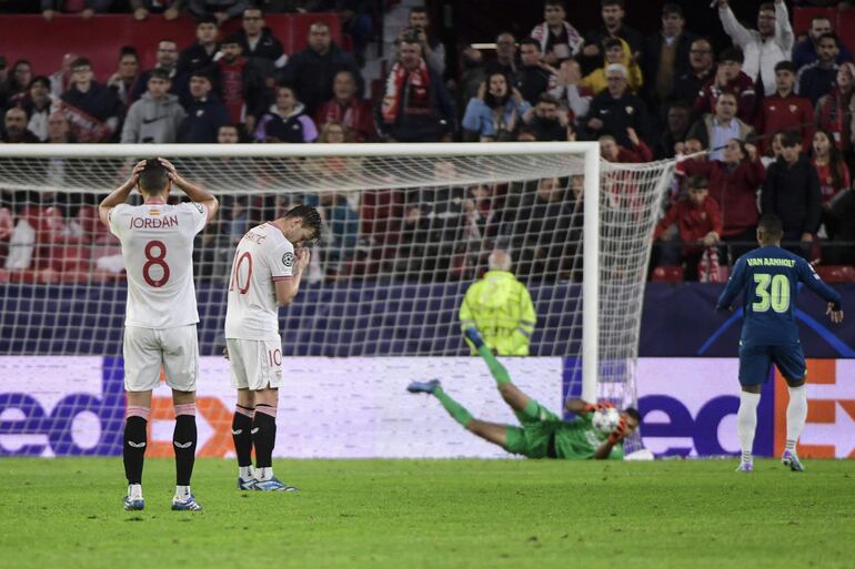 Los futbolistas del Sevilla lamentan un gol del PSV en un partido de la Champions League en el estadio Ramón Sánchez-Pizjuán, en Sevilla, España. 