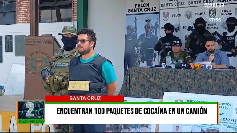 El camionero paraguayo Adalberto David Ávalos Miranda (con chaleco antibalas) y atrás el ministro de Gobierno boliviano Eduardo del Castillo (con micrófono), en la presentación de la cocaína y marihuana incautadas. (Imagen de la televisión boliviana)