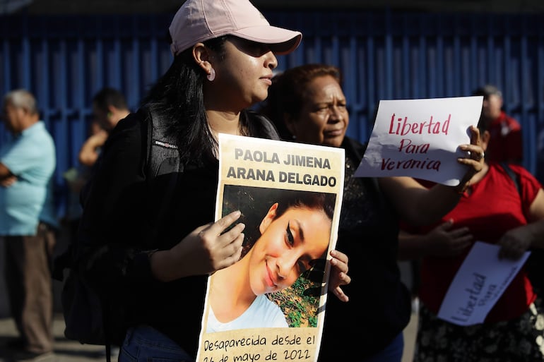 Una mujer muestra un cartel con una fotografía de Paola Delgado, desaparecida desde 2022 e hija de Verónica Delgado, detenida bajo el régimen de excepción, durante una protesta afuera de una sede judicial en San Salvador (El Salvador).