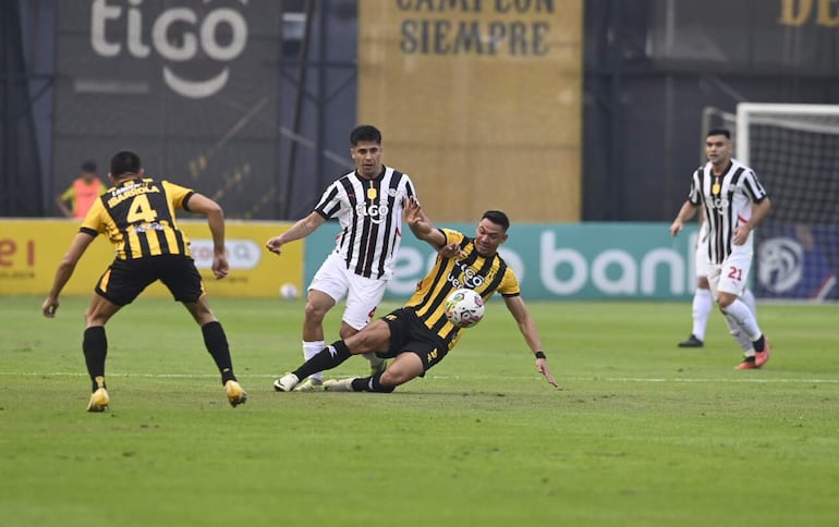 El delantero de Guaraní, Walter González, pelea por la tenencia del balón con el defensor Néstor Giménez.