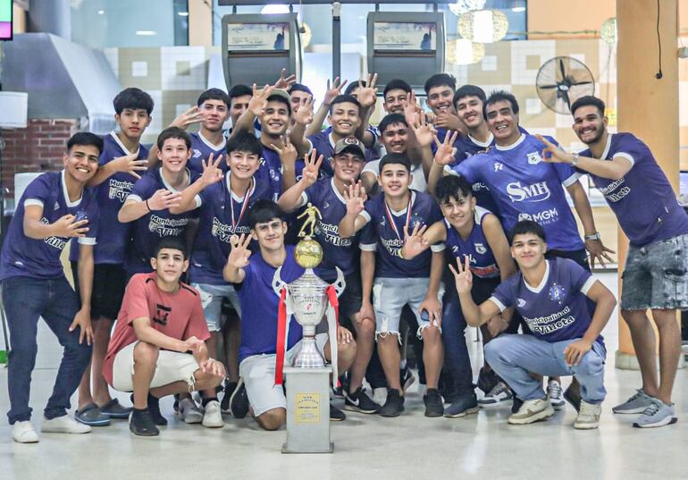 El trofeo de campeón de la categoría Juvenil, custodiado por sus ganadores, los del equipo de Cerro León FBC de Villeta.