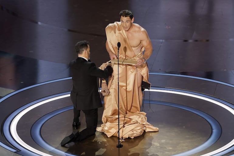 Jimmy Kimmel cubriendo a John Cena con una cortina.