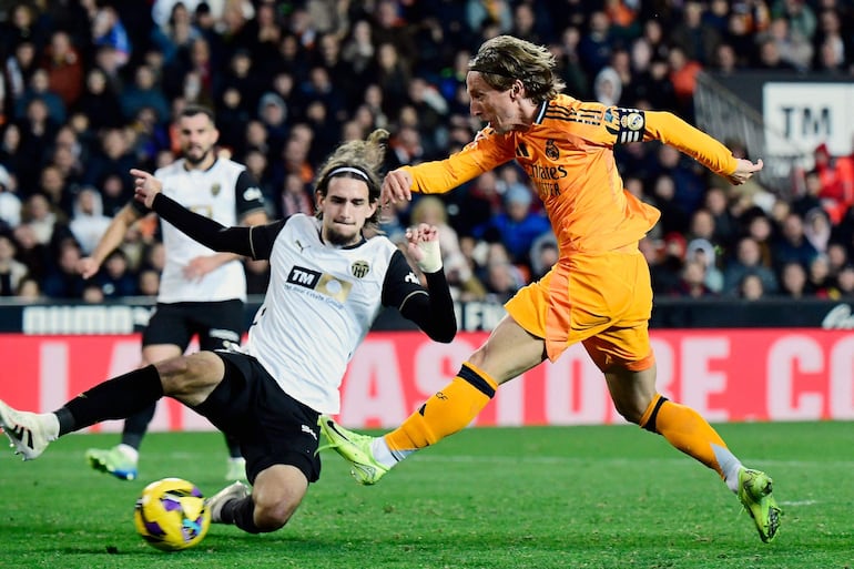 Real Madrid's Croatian midfielder #10 Luka Modric (R) shoots to score a goal during the Spanish league football match between Valencia CF and Real Madrid CF at the Mestalla stadium in Valencia on January 3, 2025. (Photo by JOSE JORDAN / AFP)