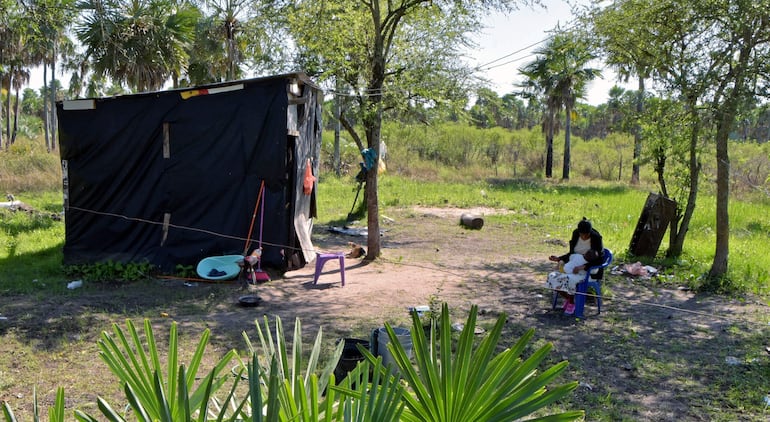 Una mujer indígena de la comunidad de Yvapovondy  amamanta a su hijo en Aguapey.