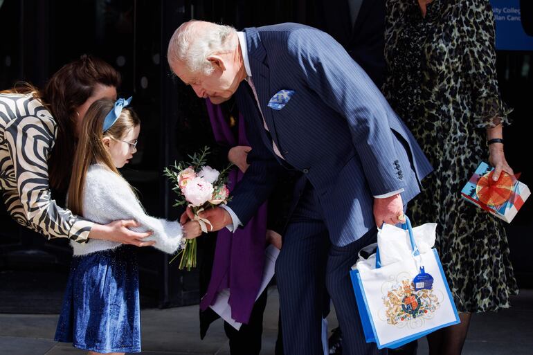 El rey Carlos III de Gran Bretaña recibe un ramo de flores de unos niños  después de visitar el Centro de Cáncer Macmillan del University College Hospital en Londres, Gran Bretaña.
