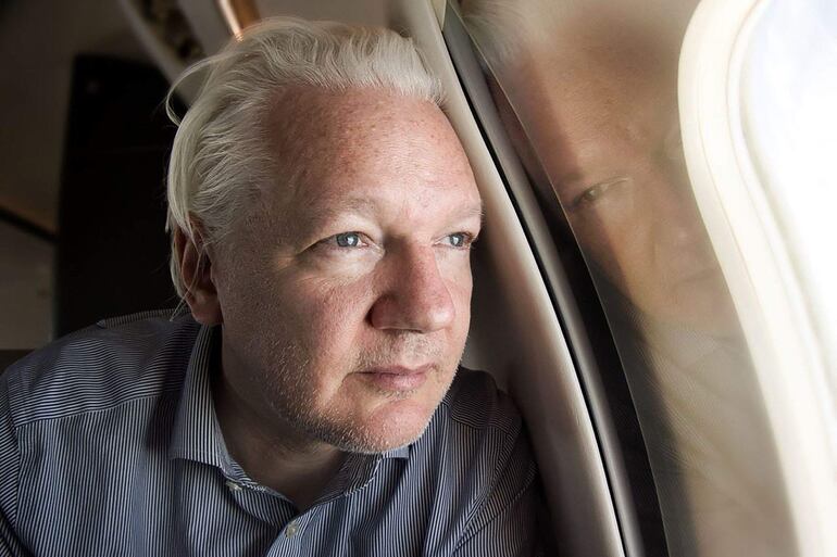 Julian Assange durante su vuelo a Bangkok, luego de su liberación en Londres, este martes.