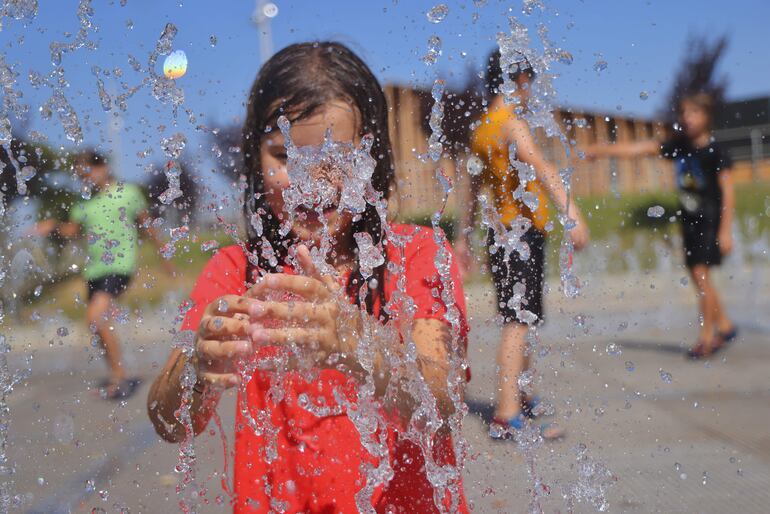 Unos niños se refrescan en una fuente en la zona de la Expo en Zaragoza para aguantar las altas temperaturas de la capital maña.