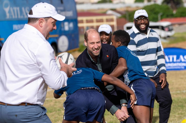 El príncipe William jugando rugby con estudiantes durante su visita a la Escuela Secundaria Ocean View en Ciudad del Cabo. (Jerome Delay / POOL / AFP)