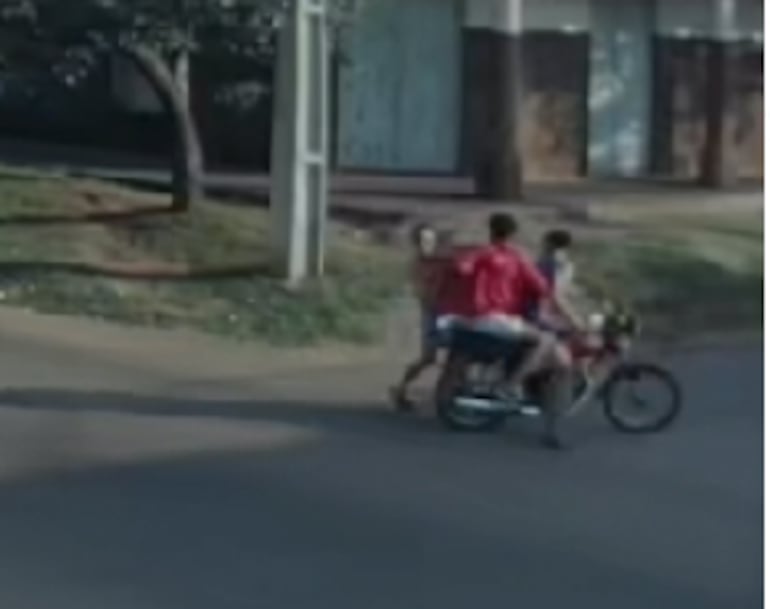 Uno de los delincuentes sujeta el bolso con una mano y con la otra aplica golpes en el rostro a la víctima, para que esta suelte su cartera.