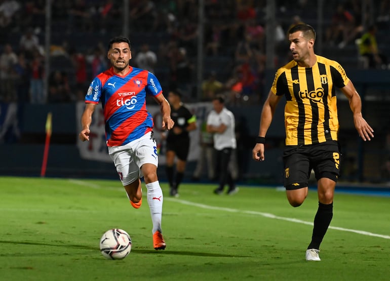 Federico Carrizo, jugador de Cerro Porteño, y Raúl Cáceres, futbolista de Guaraní, pelean por el balón en un partido por el fútbol paraguayo en el estadio La Nueva Olla, en Asunción.