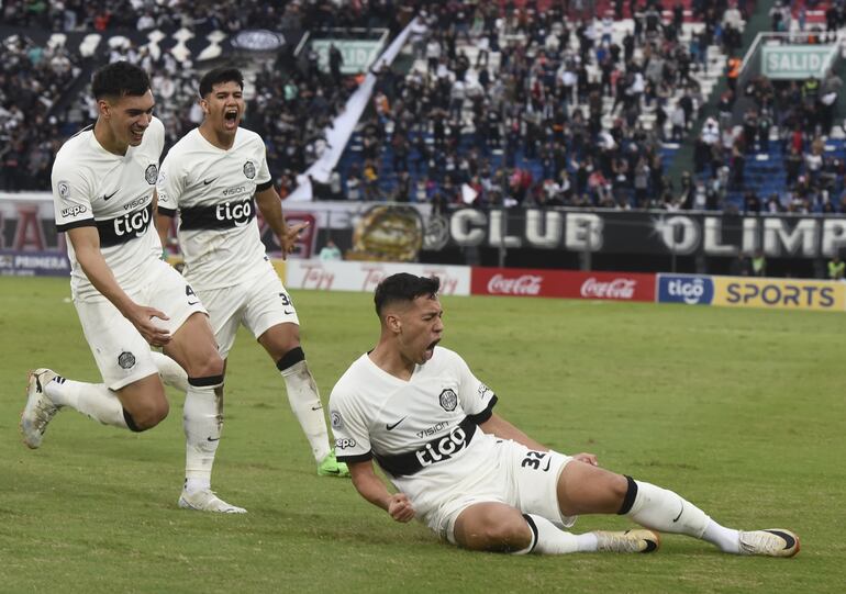 Carlos Arrúa (26) celebra a todo pulmón su tanto, el de  la victoria de Olimpia. Román (25) y Cano (19) lo acompañan.