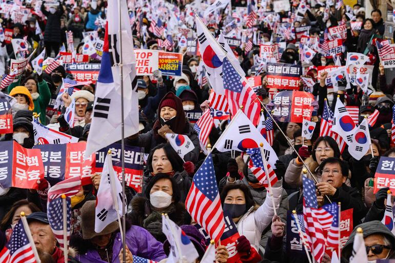 Los partidarios del presidente de Corea del Sur, Yoon Suk Yeol, asisten a una manifestación en una calle cerca del Tribunal Constitucional en Seúl el 23 de enero de 2025, después de que Yoon llegara al tribunal para las audiencias que decidirán si lo destituyen de su cargo.