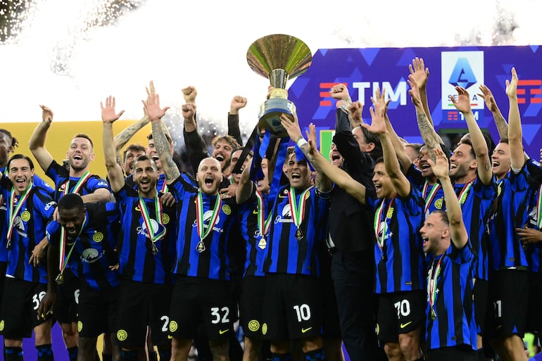 TOPSHOT - Inter Milan's Argentine forward #10 Lautaro Martinez lifts the trophy with teammates during a ceremony for the Italian Champions following the Italian Serie A football match between Inter Milan and Lazio in Milan, on May 19, 2024. Inter celebrates his 20th Scudetto. (Photo by Marco BERTORELLO / AFP)