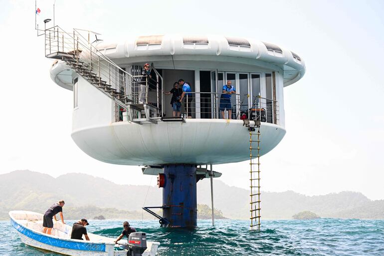 El ingeniero aeroespacial alemán Rudiger Koch, de 59 años, (a la derecha) se encuentra en el balcón del Seepod tras haber batido el récord mundial Guinness de vivir en el océano a una profundidad de once metros frente a la costa de Puerto Lindo, Panamá.