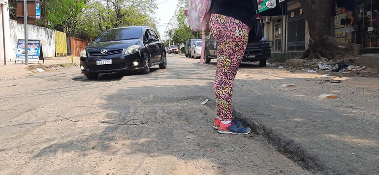 En la imagen se aprecia como un conductor esquiva el bache, Mientras que un peatón muestra la profundidad de los raspados que dejan las empresas contratadas con la municipalidad.