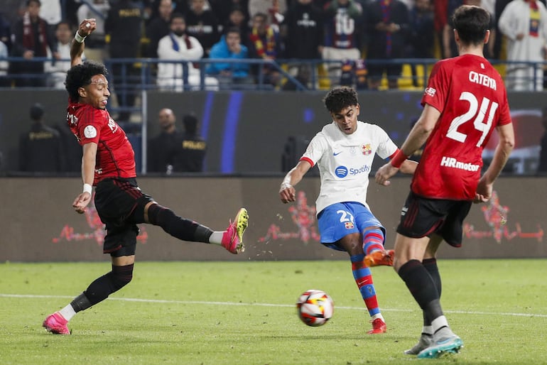 RIAD (ARABIA SAUDÍ), 11/01/2024.- El delantero del Barcelona Lamine Yamal (c) chuta para marcar el segundo gol ante Osasuna, durante la segunda semifinal de la Supercopa de España que FC Barcelona y CA Osasuna que han disputado este jueves en el estadio Al-Awwal Park de Riad, en Arabia Saudí. EFE/Juan Carlos Cárdenas
