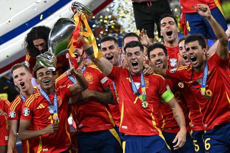 TOPSHOT - Spain's forward #07 Alvaro Morata (C) rises the trophy next to Spain's midfielder #16 Rodri (R) and Spain's forward #19 Lamine Yamal (2L) after winning the UEFA Euro 2024 final football match between Spain and England at the Olympiastadion in Berlin on July 14, 2024. (Photo by JAVIER SORIANO / AFP)