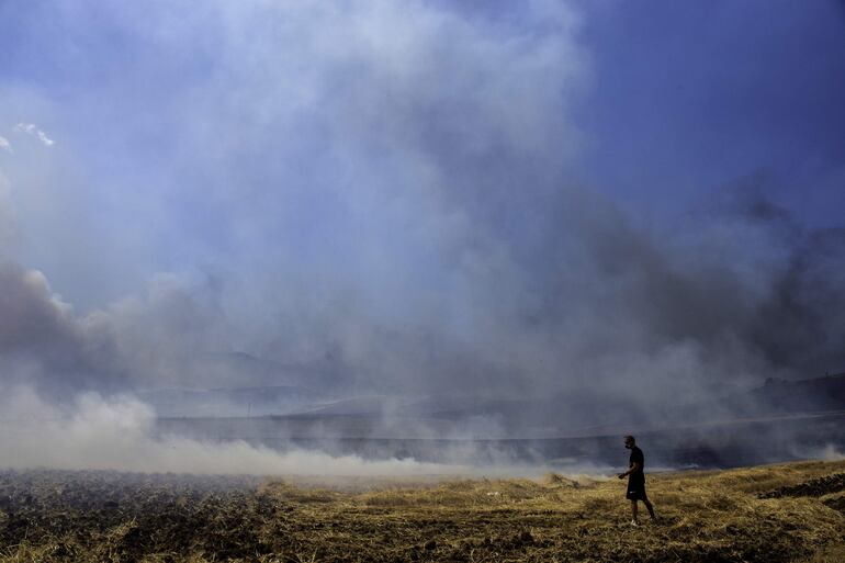 Un hombre mira los campos quemados durante un incendio este jueves en Velestino, Grecia, una zona asolada por el fuego.