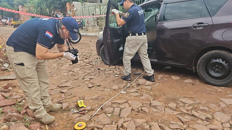 Policías de Criminalística analizan la escena del crimen registrado ayer en la ciudad de Lambaré. Inspeccionaron el vehículo de la víctima que no registraba rastros de bala ni sangre.