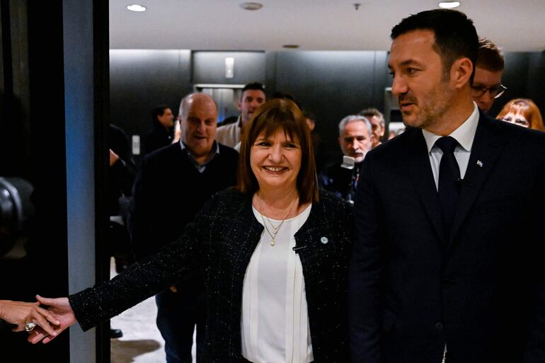 La precandidata presidencial, Patricia Bullrich (c) junto a su candidato a vicepresidente Luis Petri (d), en Buenos Aires. (AFP)