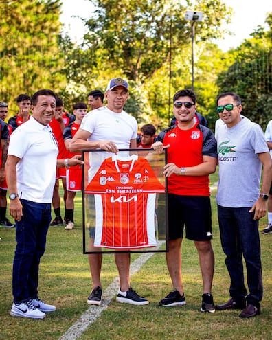 Gustavo Arévalos recibe la camiseta encuadrada de General Caballero de Juan León Mallorquín. Lo acompañan el presidente Julio César Aldama (izq.), el gerente deportivo Julio Sebastián Aldama y el vicepresidente Óscar Gavilán Dávalos. El emotivo momento se vivió en las instalaciones de Puma Resort.