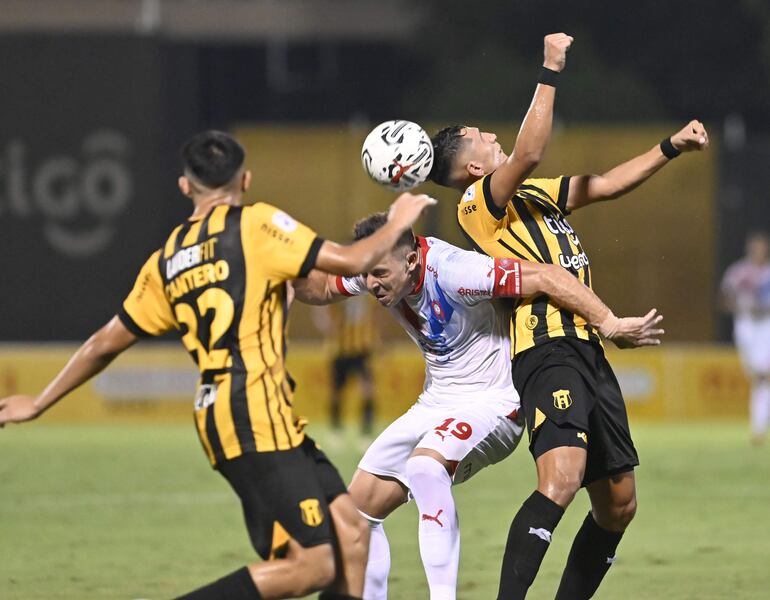 Paul Riveros desvía el balón con la cabeza para evitar que Diego Churín pueda quedarse con el esférico.