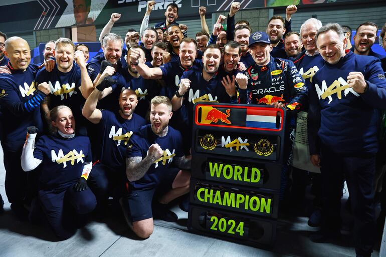 Max Verstappen (27), con los puños cerrados, conmemora el título acompañado de todo el equipo.