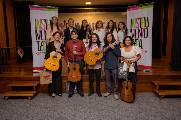 Berta Rojas y Marcelo Toyotoshi posan con los ocho jóvenes que se adjudicaron las guitarras en la segunda edición de la "Instrumentoteca Toyota".