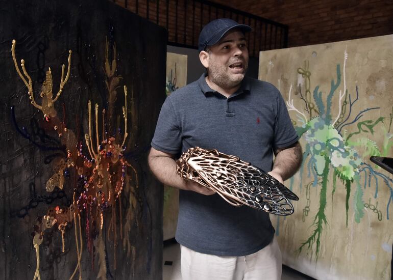 El artista Andrés Paredes exhibe una cigarra elaborada con madera y resina, que también se exhibirá en la feria.