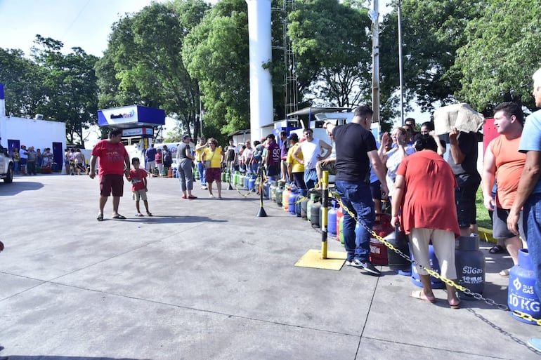 Con una temperatura superior a los 30ºC, una gran cantidad de personas forma fila y espera que su garrafa sea recargada.