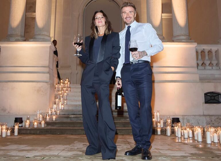 Victoria y David Beckham brindando juntitos tras el exitoso desfile en París.