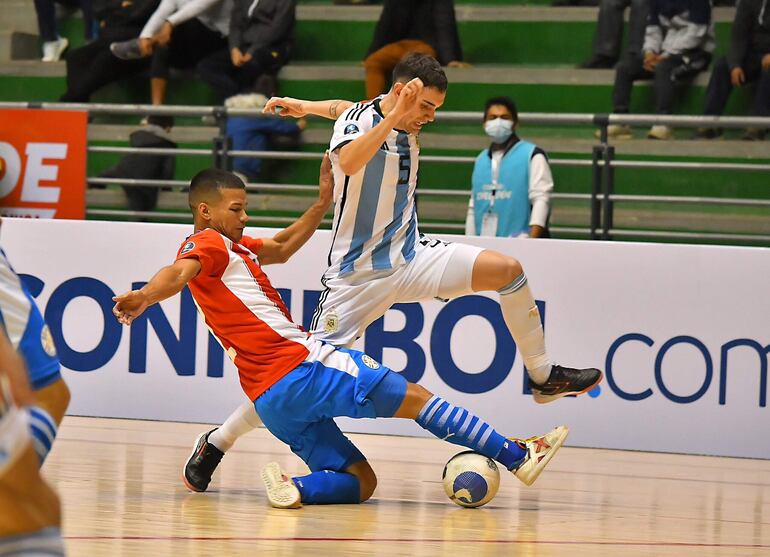 El albirrojo Alan Rojas se esfuera paa detener la marcha del jugador argentino en la Liga Evolucion Zona Sur. Hugo paridad de 2-2.