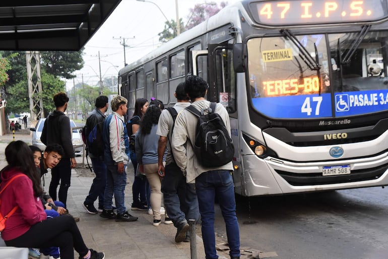 Pasajeros forman fila para subir al bus luego de una larga espera.