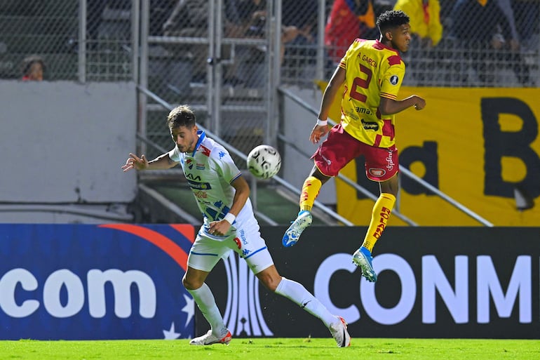 El defensor de Aucas Alan García pasa de largo al intentar despejar el balón que queda a disposición del delantero Ignacio Bailone