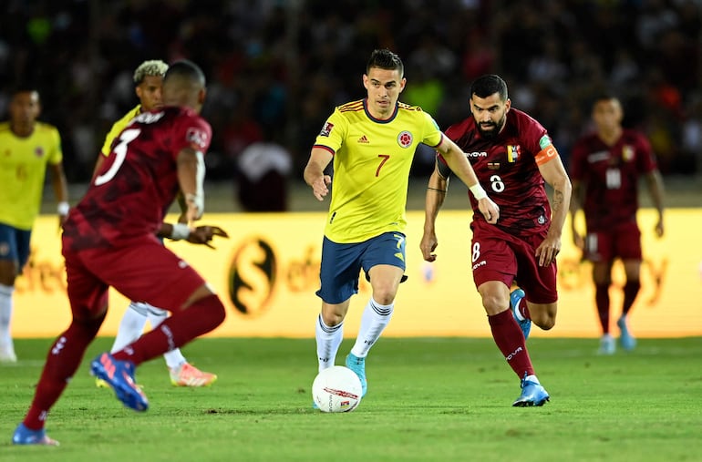 Rafael Santos Borré (c), futbolista de la selección de Colombia, domina el baló ante la marca de Tomas Rincón (d), jugador de Venezuela, en un partido delas Eliminatorias Sudamericanas al Mundial Qatar 2022 en el estadio Polideportivo Cachamay, en Puerto Ordaz, Venezuela.