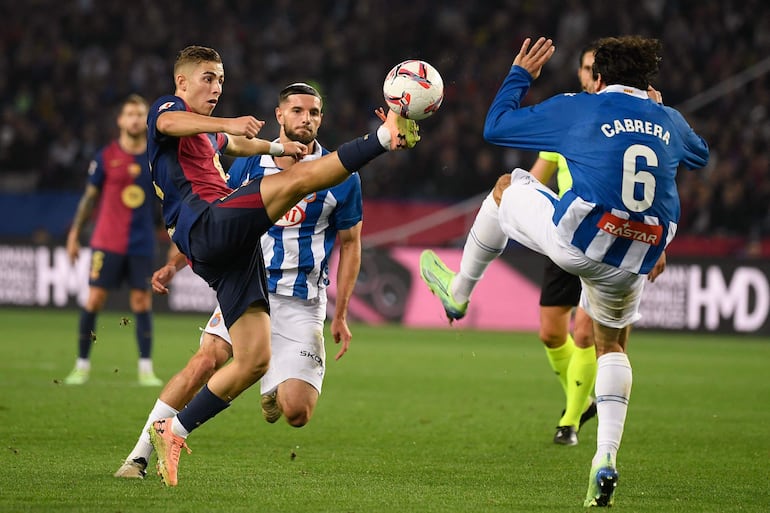 Barcelona's Spanish midfielder #16 Fermin Lopez (L) is challenged by Espanyol's Uruguayan defender #06 Leandro Cabrera during the Spanish league football match between FC Barcelona and RCD Espanyol at the Estadi Olimpic Lluis Companys in Barcelona, on November 3, 2024. (Photo by Josep LAGO / AFP)