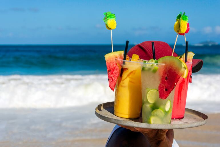 Un vendedor ambulante ofrece caipirinha, caipifruta y otras bebidas en una playa de Brasil.